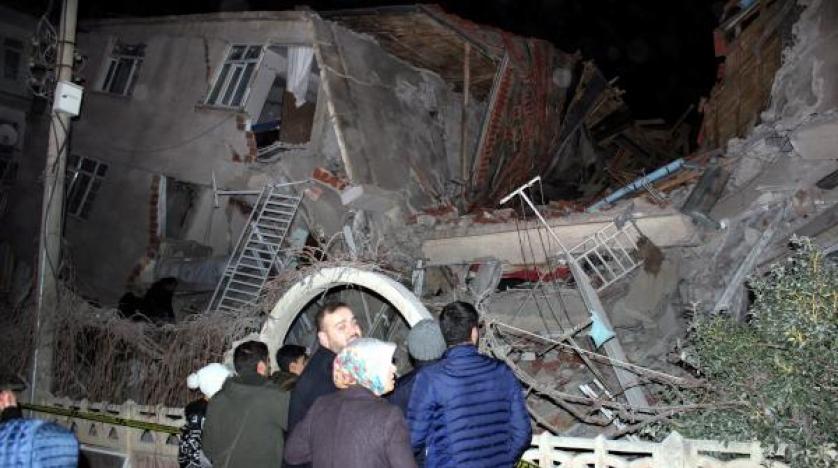 People stand outside a collapsed building after an earthquake in Elazig reuters